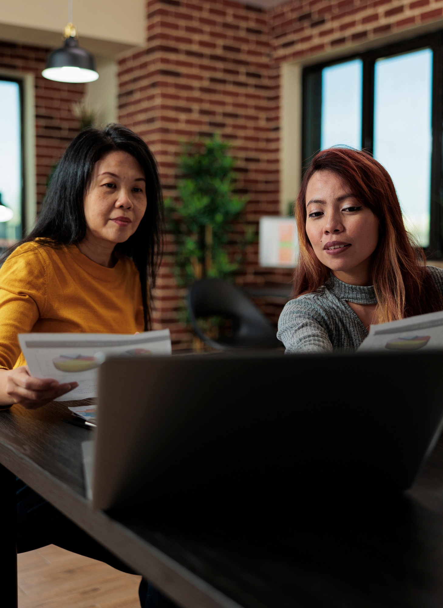 Businesswomen holding business papers discussing management strategy