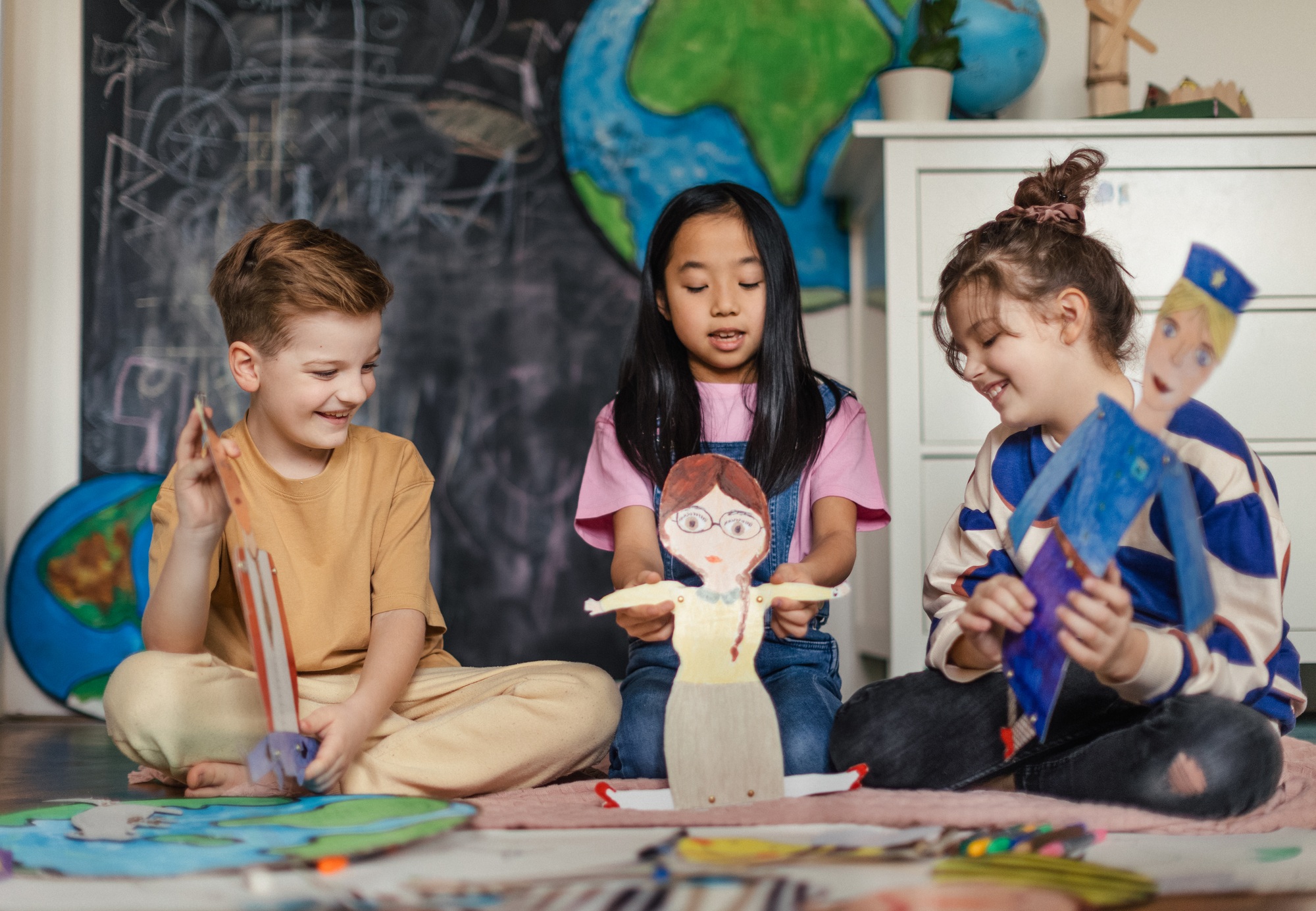 Little children playing with a handmade puppets.